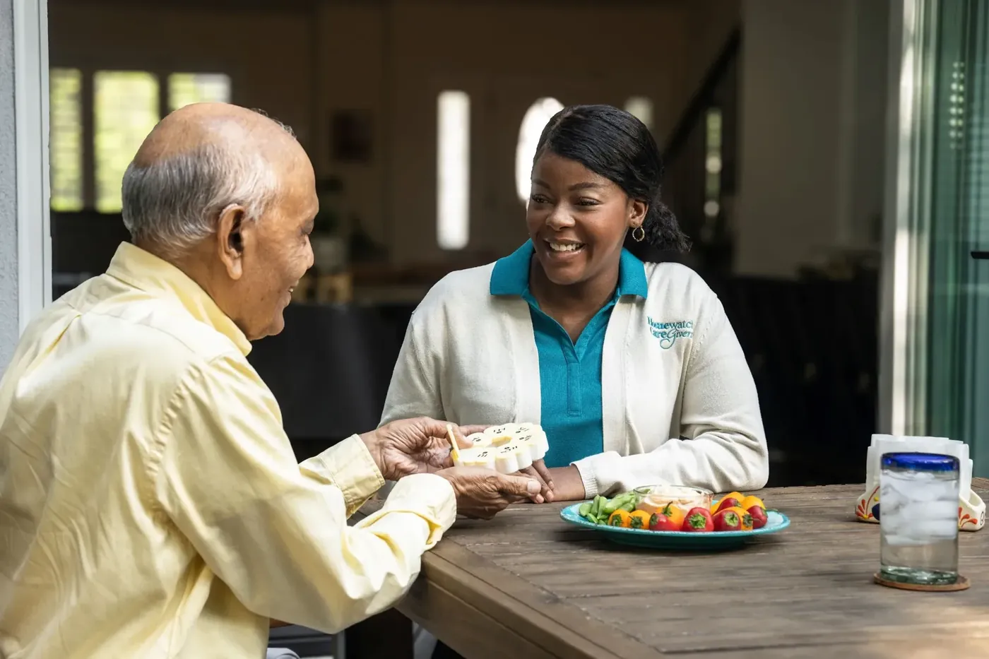 A Homewatch caregiver sitting with a client over a meal