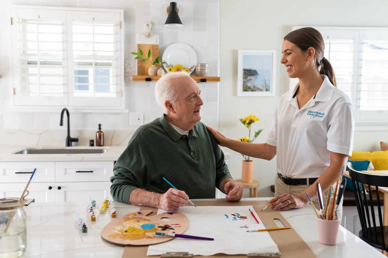 A Homewatch caregiver with a client at his kitchen table