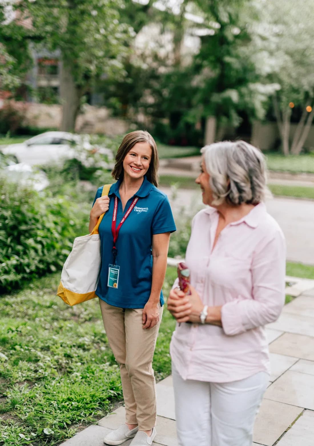 A Homewatch caregiver walking outside with a client